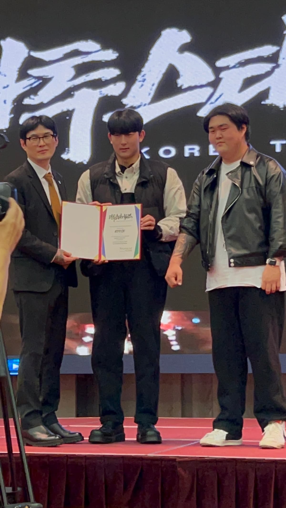 Hajun Ko receiving the TattooStar award certificate